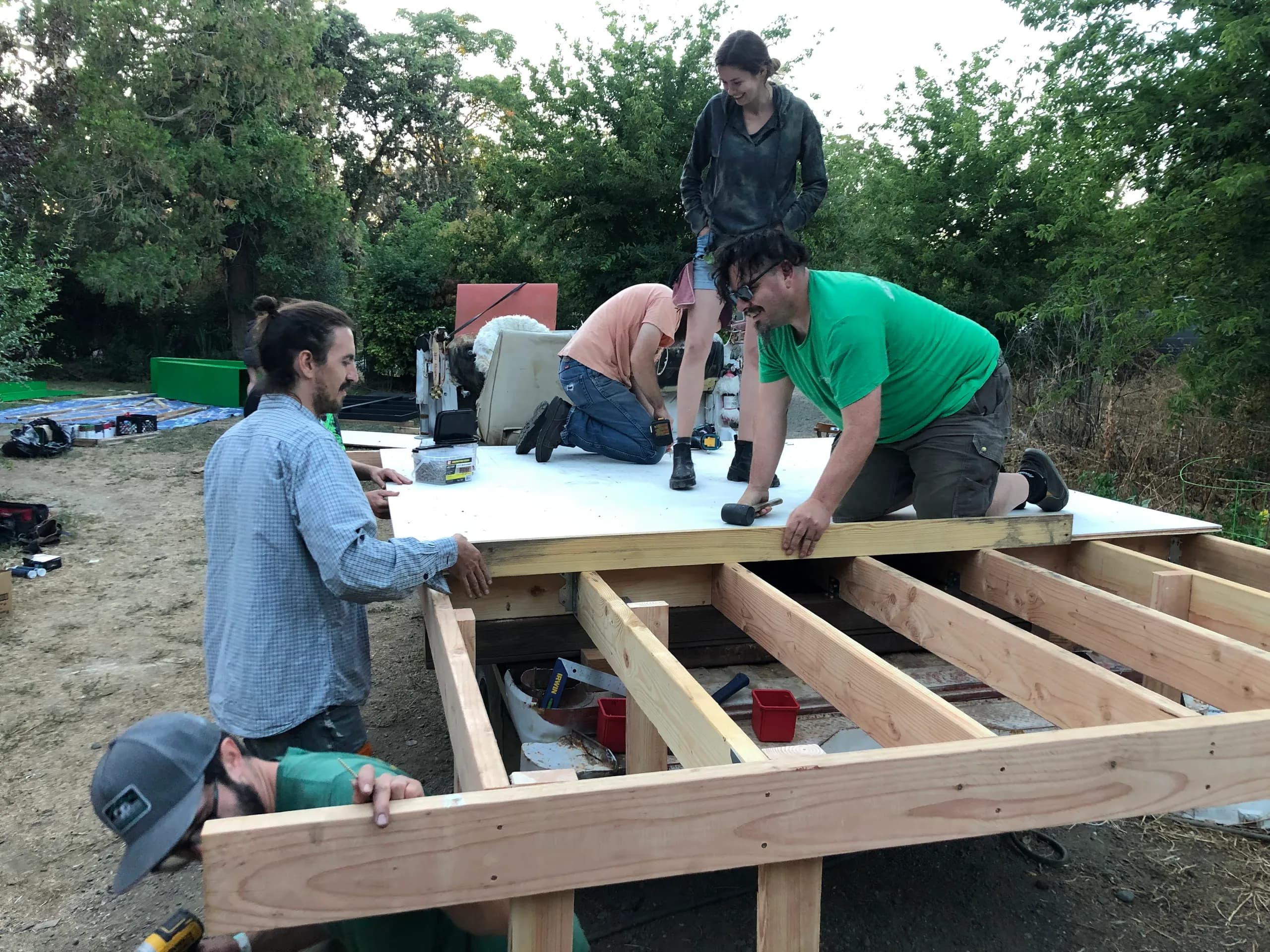 Crew members hammering the dance floor deck onto the truck frame in a backyard
